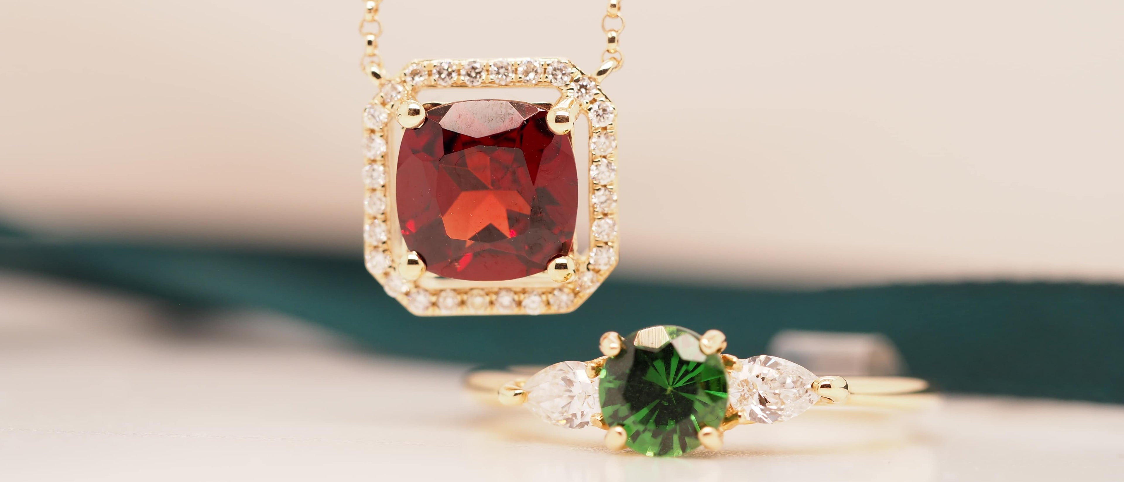 A pair of jewelry, each with diamond accents surrounding a gemstone