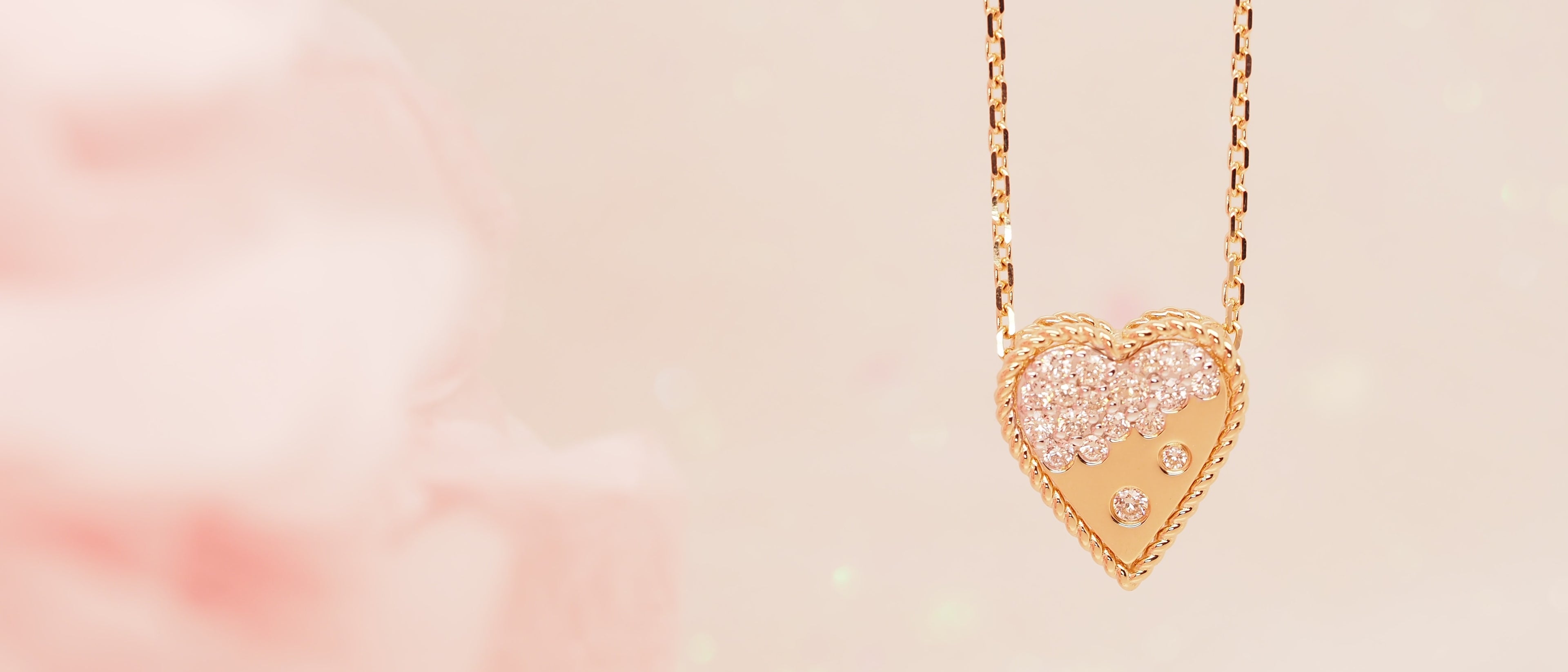 A heart-shaped necklace encrusted with diamonds on a chain